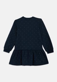 Vestido azul-marinho de mangas compridas com decote redondo, apresentando uma saia franzida e detalhes em pontos prateados dispersos. Tecido em mistura de algodão macio.