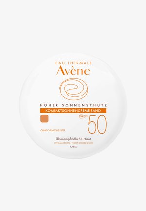 White circular compact with orange text. Displays brand name "Avene," product type "Kompaktsonnencreme Sand," and SPF 50. No chemical filters.