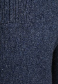 Dunkelblauer, gestrickter Wollpullover mit einem dezenten Rippmuster und weicher, flauschiger Textur.