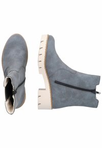 Grå textilankelstövlar med sidogångjärn, kraftiga vita klackar och en mjuk innerfoder. Har texturerad yta och sömnadsdetaljer.