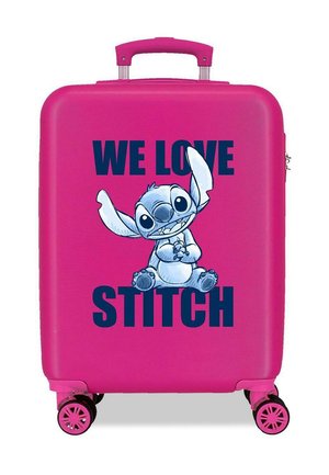 Maleta rígida de color rosa brillante con cuatro ruedas, con un personaje alienígena de dibujos animados sentado y texto que dice "AMAMOS A STITCH" en letras gruesas.