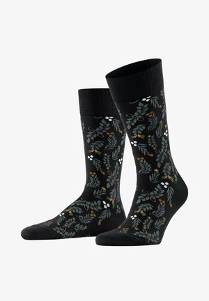 Schwarze, knielange Socken mit einem grünen und braunen, blattartigen botanischen Muster und kleinen weißen Beerentrauben.