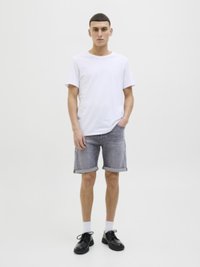 Hvid bomulds t-shirt, grå denim shorts med opkørte kanter, sorte sko og hvide sokker. Enkel design, afslappet pasform, minimal detaljering.