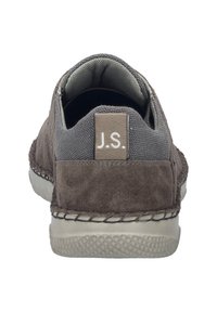 Graue Wildlederschlupfschuhe mit einem strukturierten Stoffeinsatz, genähten Details und einem kleinen Etikett mit der Aufschrift "J.S." an der Ferse.
