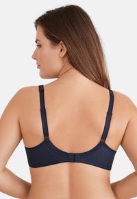 Granatowy biustonosz o teksturowanym wykończeniu, z regulowanymi ramiączkami oraz zapięciem na haftkę z tyłu. Minimalistyczny design bez ozdób.