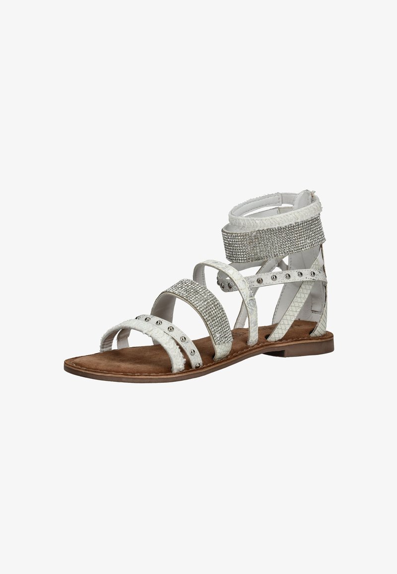 White flat sandal with multiple straps, adorned with silver studs and rhinestones, and a zip closure at the back.