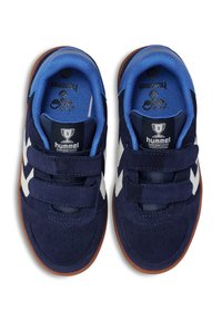 Mörkblå sneakers i mocka med vita gummidetaljer, försedda med kardborreband och en strukturerad gummisul. Blå vadderad krage inuti.