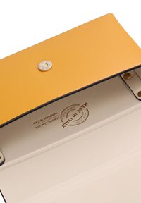 Portafoglio giallo in pelle con una texture liscia, dotato di chiusura a scatto in argento. All'interno presenta una fodera crema e un'etichetta in rilievo "Made in Italy".