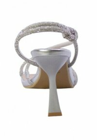 Sandalo con tacco alto argentato, con cinturini embelliti da cristalli, apertura sul retro e tacco sottile. Materiale liscio con finitura lucida.
