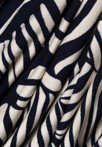 Navy and cream fabric with a wavy, abstract pattern. The material appears smooth with a soft texture, displaying gentle folds.