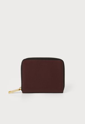 Portafoglio compatto con esterno in pelle bordeaux, zip dorata e bordi in tessuto nero. Presenta una texture semplice e liscia.
