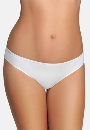 Frauenmitte, die schlichte weiße, tief geschnittene Bikini-Unterwäsche vor einfachem Hintergrund trägt.