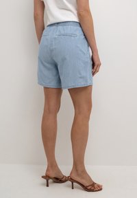 Vaaleansiniset farkkushortsit, joissa on joustava vyötärö, suora malli ja takataskut. Sileä rakenne, rento muotoilu, joka sopii lämpimille sääolosuhteille.