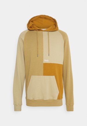 Huppari, jossa on väriblokki-design beigeä ja sinappia, puuvillamateriaalia, kengurun tasku ja logodetalji edessä.