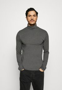 Grauer Rollkragenpullover mit langen Ärmeln aus weichem Material, schmaler Schnitt, nahtlose Schultern, mit glatter Textur und minimalen Nähten.
