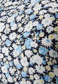 Floral fabric featuring small blue, yellow, and white flowers on a black background with a textured, soft surface.