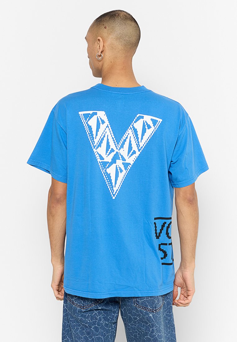 T-shirt en coton bleu avec un grand motif géométrique blanc en forme de "V" au dos et un accent de texte noir, coupe décontractée avec manches courtes.