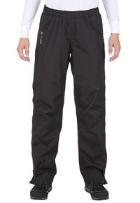 Person, der schwarze Outdoor-Hosen mit elastischem Bund und kleinem weißen Logo auf der linken Seite sowie schwarze Wanderschuhe trägt, vor weißem Hintergrund steht.