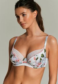 Reggiseno con motivo floreale in tessuto azzurro chiaro, rifinito in pizzo con spalline regolabili. Presenta coppe imbottite e arricciature al centro per supporto.