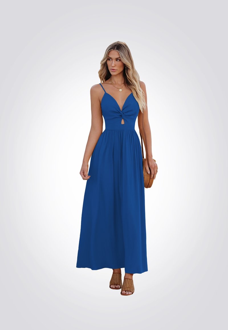 Vestido maxi azul con un profundo escote en V y detalle retorcido en la cintura. Tirantes finos, tela fluida y un corte en forma de ojal. Zapatos de tejido y bolso.