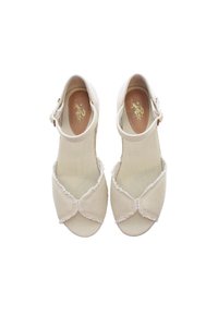 Beiga canvas skor med rund tå, dekorativ rosettdetalj och fransade kanter; justerbart vristband; guldfärgad logotyp på insidan av skorna.