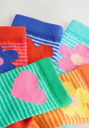 Spalvingos kojinės su įvairiais raštais: oranžiniai su mėlyna gėle, mėlyni dryžuoti, žali su rožine širdimi ir geltoni su gėle.