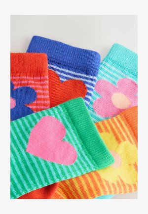 Spalvingos kojinės su įvairiais raštais: oranžiniai su mėlyna gėle, mėlyni dryžuoti, žali su rožine širdimi ir geltoni su gėle.