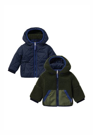 Veste réversible pour tout-petit avec côté matelassé bleu marine et côté polaire sherpa vert, les deux avec capuches et fermetures éclair devant, présentée à plat.