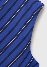 Tissu bleu avec des rayures diagonales bleu marine et blanches, montrant un gros plan de l'épaule et de l'emmanchure d'un vêtement sur un fond blanc.