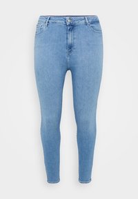 Jeans skinny de mezclilla de color azul claro con cintura alta, cinco bolsillos y cierre de botón en la parte frontal. Presenta una textura suave y lisa.