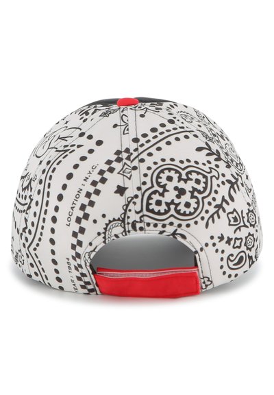Biała czapka baseballowa z czarnymi wzorami paisley, czerwonymi akcentami z tyłu, o zaokrąglonym kształcie i z zapięciem typu snapback.