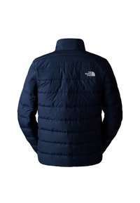Granatowa kurtka puchowa z pikowanym wzorem, wysokim kołnierzem oraz białym logotypem The North Face na górnej części pleców. Gładki, wodoodporny materiał.
