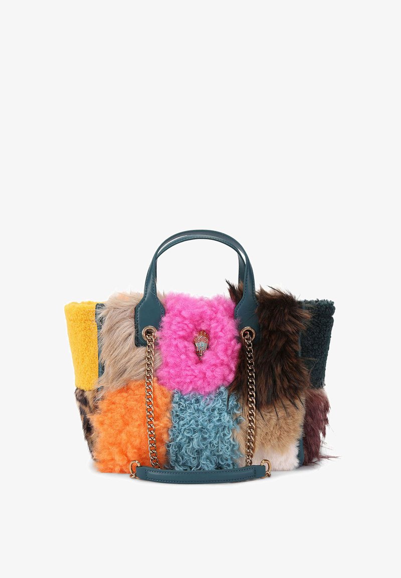 Torba tote z imitacji futra z wielokolorowymi łatami w kolorach różowym, pomarańczowym, żółtym, zielonym i brązowym. Posiada turkusowe uchwyty i złoty akcent w postaci łańcuszka.