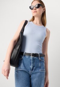 Lyseblå ribbet tank top, svart skinn skulderveske, svart belte med sølvspenne, høy midje denim jeans, svarte solbriller.