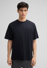 Zwart katoenen t-shirt met een ronde hals, korte mouwen en een relaxte pasvorm. Gladde textuur, geen zichtbare patronen of accenten.