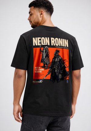 Mann trägt ein schwarzes T-Shirt mit einem roten Motiv von zwei futuristischen Kriegern und dem Text "NEON RONIN" und "WAY OF THE CHROME WARRIOR" auf dem Rücken.