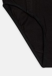 Slip in cotone nero con una superficie liscia, cintura elasticizzata e cuciture curate sui bordi per una maggiore durata.