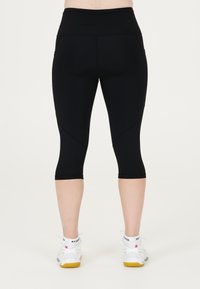 Svarta capri leggings med hög midja, med en slät yta och en figurnära design. Synliga sömmar och en kortad längd.