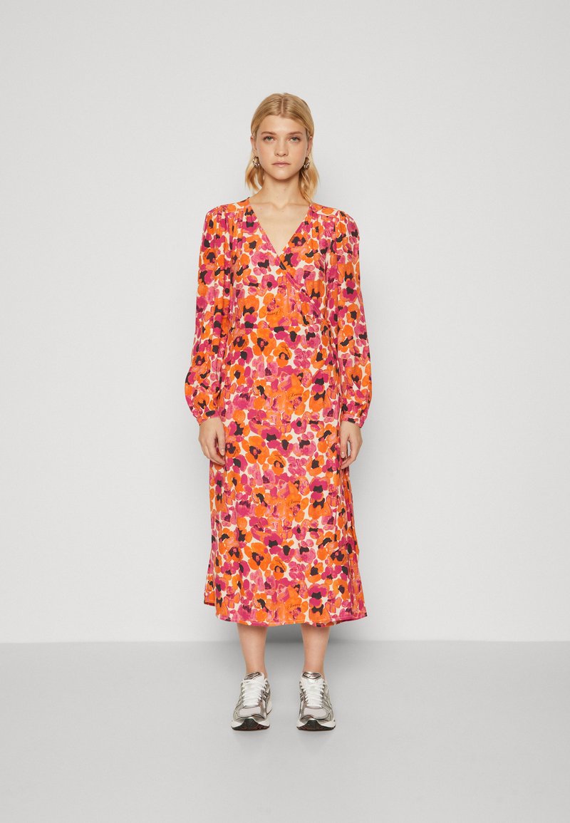 Lång, blommig klänning i starka nyanser av rosa, orange och svart, med lång ärm och djup V-urringning, tillverkad av lättviktsmaterial.