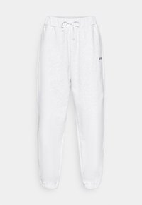 Witte joggingbroek van zacht materiaal, met een tailleband met trekkoord, taps toelopende boorden en een klein logo aan de linkerkant.