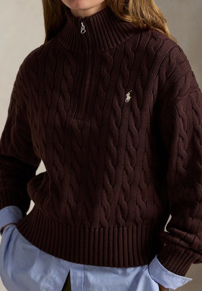 Vínový pletený sveter s vysokým golierom, zdobený káblovým vzorom, s rebrovanými manžetami a predným polozipsom. Na hrudi malý logo akcent.