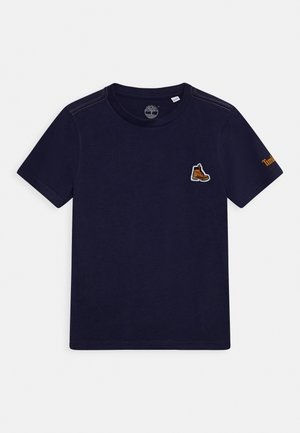 Marineblå T-shirt med korte ærmer og rund halsudskæring, med lille støvlepatch på brystet og Timberland-logo på venstre ærme.