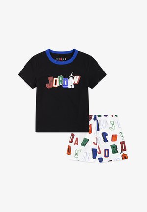 T-shirt preta com logótipo "JORDAN" colorido e gola azul, combinado com calções brancos com padrões de letras multicoloridos.