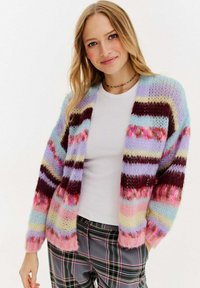 Wielokolorowy, dziergany kardigan z poziomymi paskami w pastelowych odcieniach niebieskiego, różowego, fioletowego i burgundowego. Otwarty przód, luźny krój.