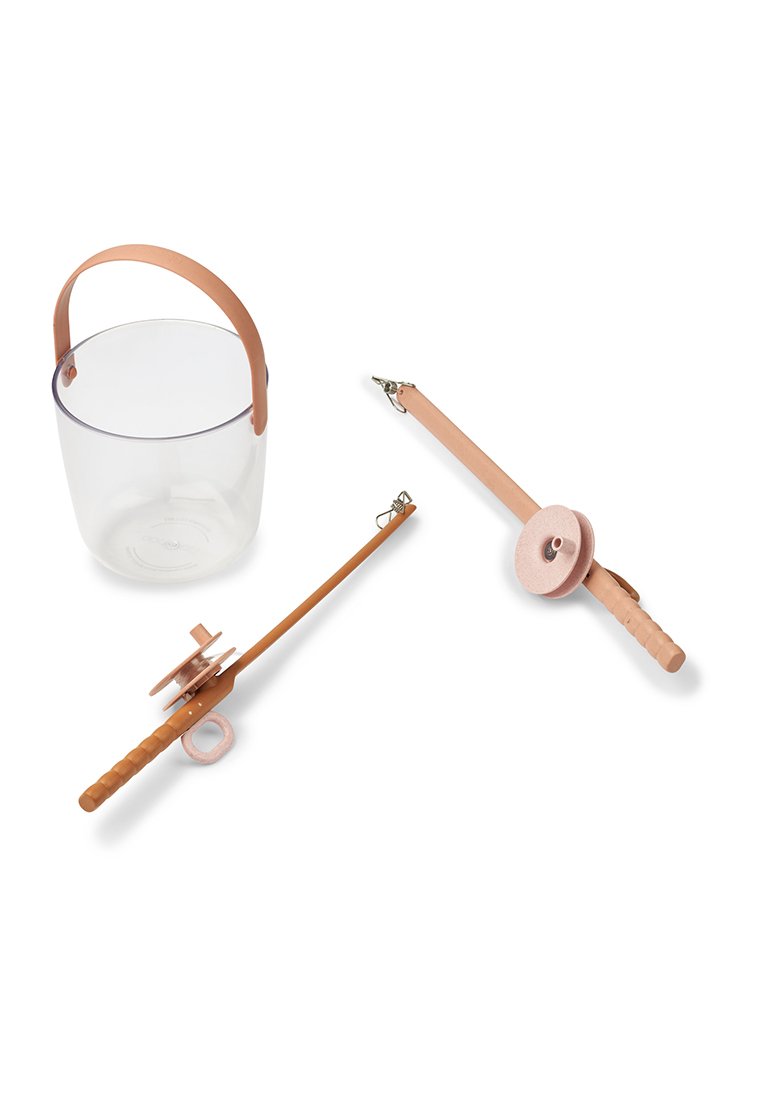 Un seau transparent avec une poignée en cuir beige, à côté d'une laisse beige avec une poignée ronde et un clip, ainsi qu'une bobine rose et ronde pour le rangement.