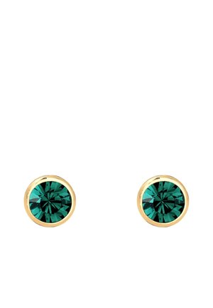 Boucles d'oreilles en or avec des pierres précieuses facettées rondes de couleur verte profonde dans un sertissage simple à griffes sur un fond blanc.