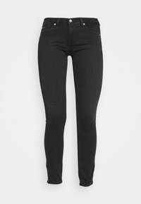 Jeans skinny negros de denim, con un diseño de cintura alta, bolsillos delanteros y traseros, y cremalleras en los dobladillos de los tobillos.