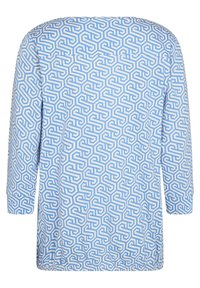 Top azzurro chiaro con un motivo geometrico in bianco e blu scuro. Maniche lunghe, scollatura rotonda e una vestibilità morbida.