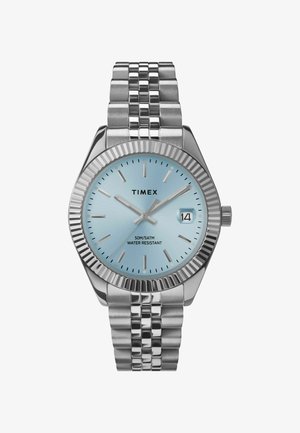 Montre en acier inoxydable argenté avec une lunette texturée, un cadran bleu clair, des index argentés et une fenêtre de date ; étanchéité de 50 m.