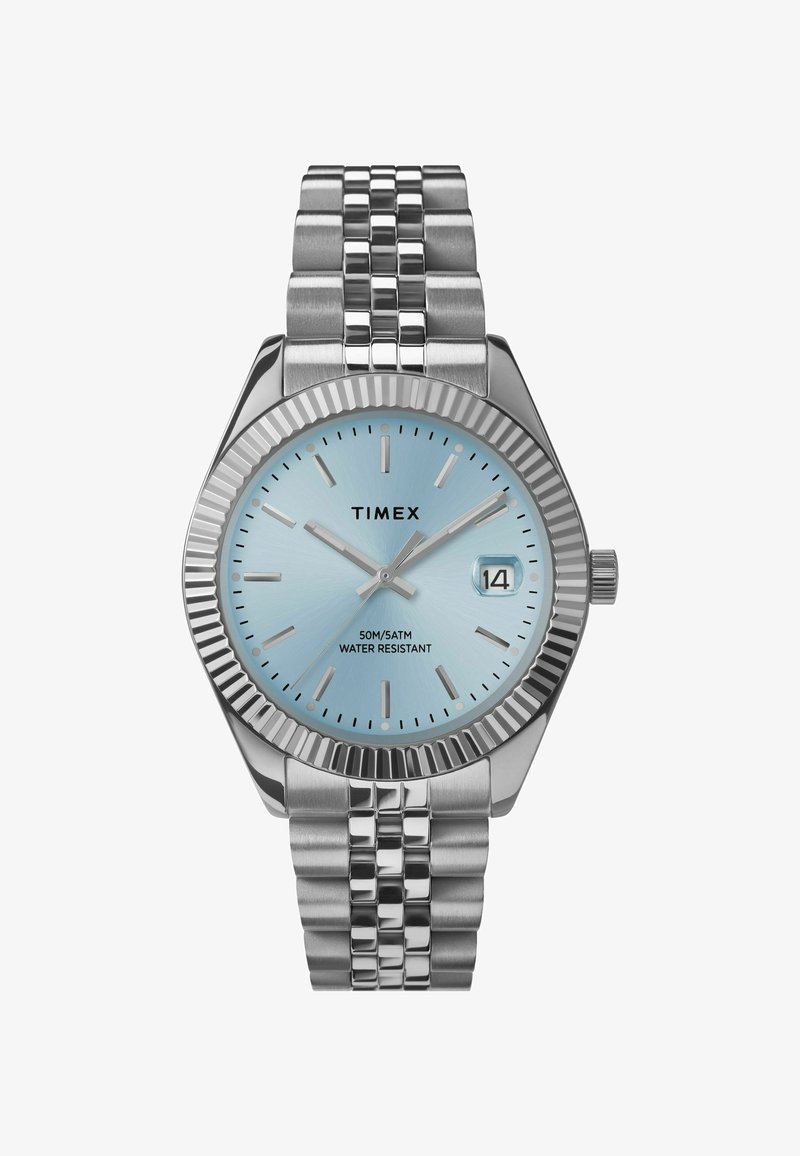 Montre en acier inoxydable argenté avec une lunette texturée, un cadran bleu clair, des index argentés et une fenêtre de date ; étanchéité de 50 m.